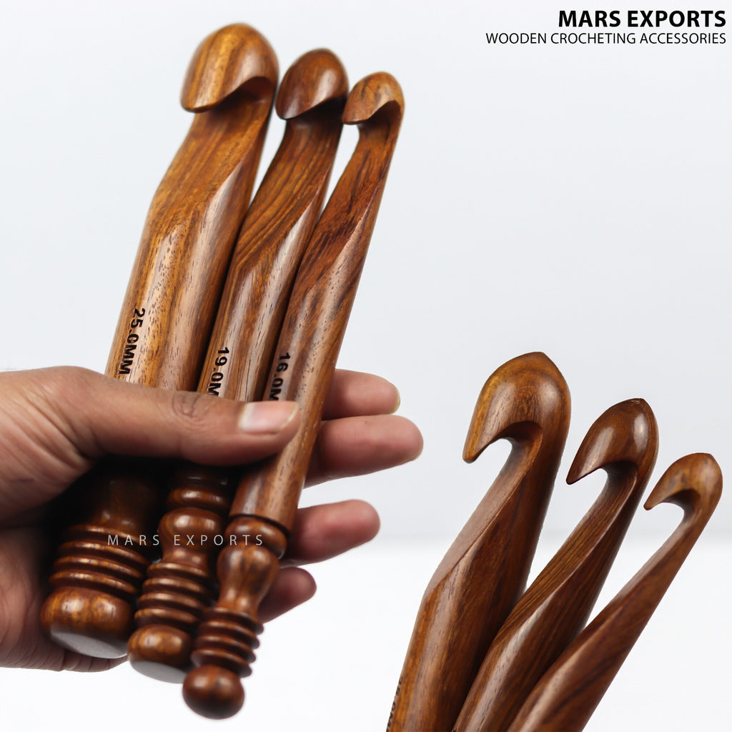 Three large rosewood crochet hook sizes shown at hand scale