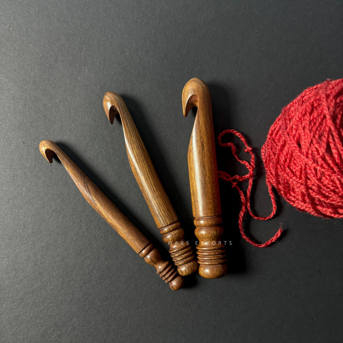 Antique brown rosewood crochet hooks on a dark background