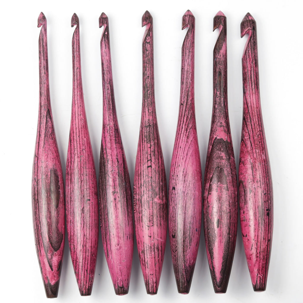 Seven-piece antique red dolphin crochet hook set on white background