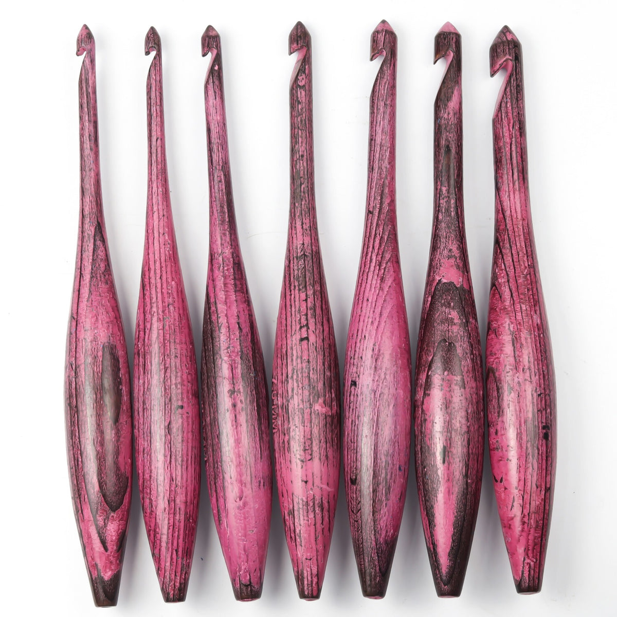 Seven-piece antique red dolphin crochet hook set on white background