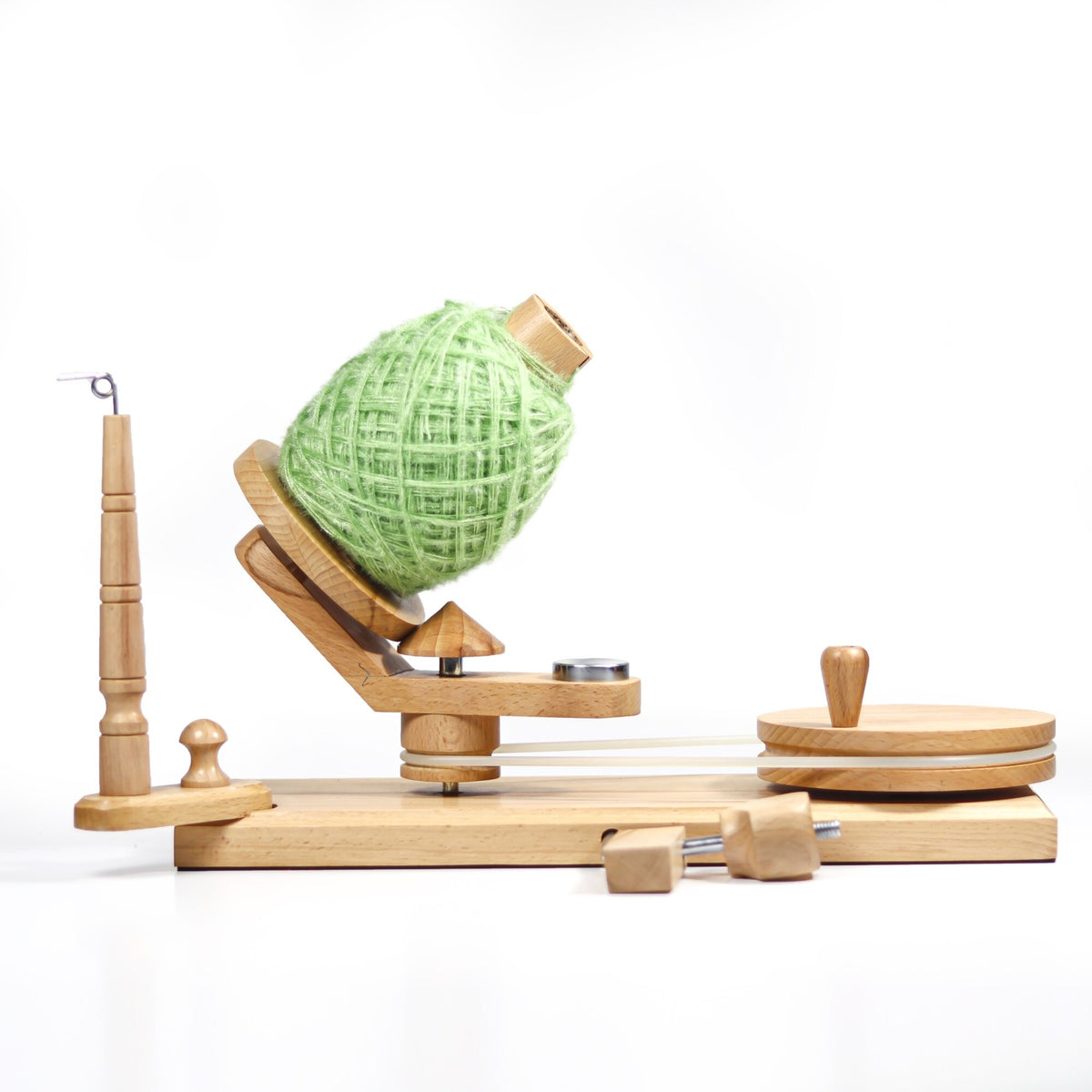 Manual beechwood yarn winder shown creating an organized yarn cake